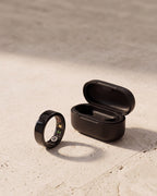 [Black] Lumo Ring in black with charging case on stone