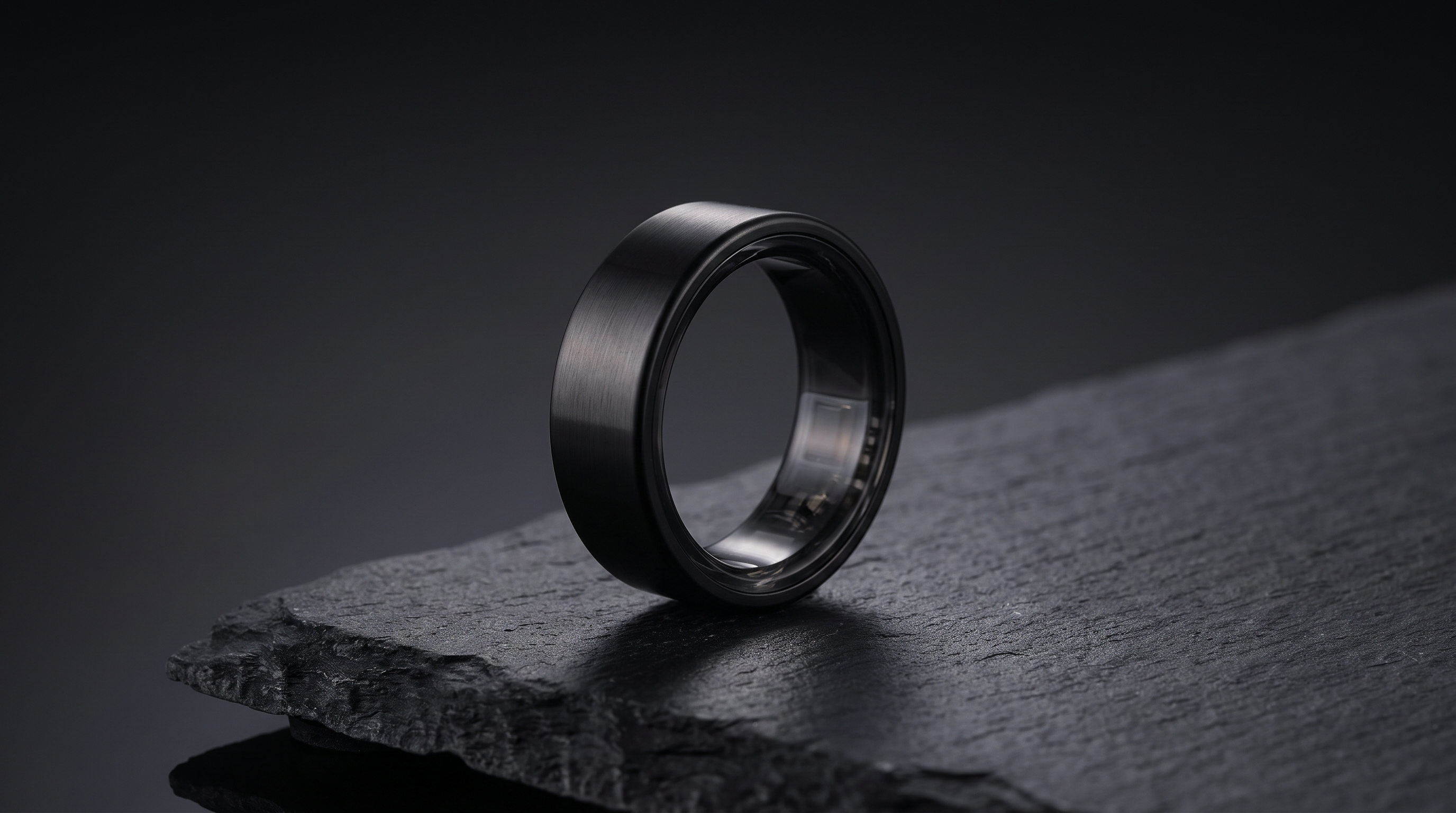 Lumo Ring hero, black ring on slate